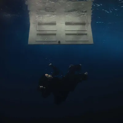 A person is shown underwater, seemingly falling, with a door floating above them.