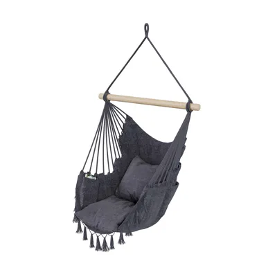 A hanging chair with a pillow and tassels, suspended from a wooden bar.