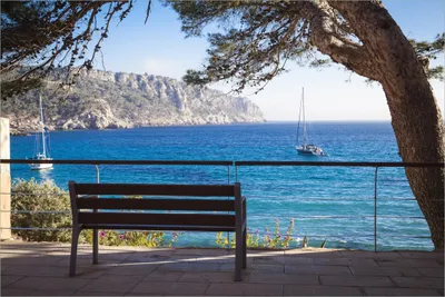 Produktbild von Wallario selbstklebendes Poster - Einsame Bank am Meer - Spanien im Sommer, Größe: 61 x 91,50 cm