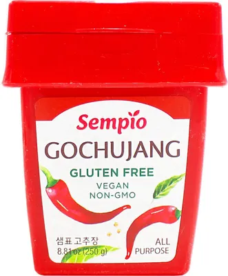 A red container of Sempio Gochujang with a label showing chili peppers and text.