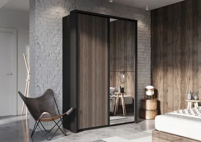 A modern bedroom with a large wardrobe, a butterfly chair, and a bed.