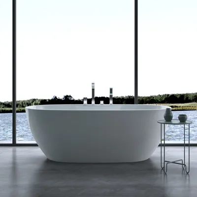 A freestanding bathtub is placed in front of a large window overlooking a body of water and trees. A small side table with two vases sits next to the bathtub.