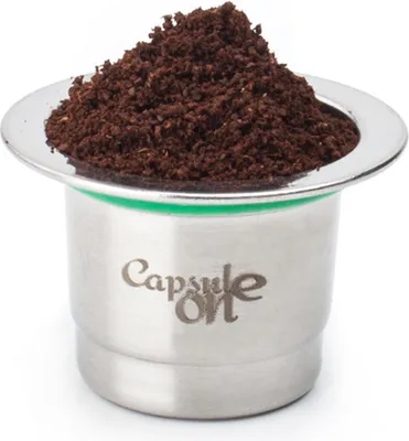 A reusable stainless steel coffee capsule filled with coffee grounds.