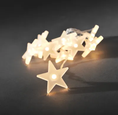 A string of LED lights shaped like frosted stars on a dark gray background.