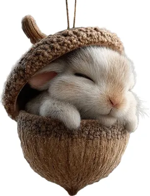 A cute, fluffy bunny sleeping inside a crocheted acorn ornament.