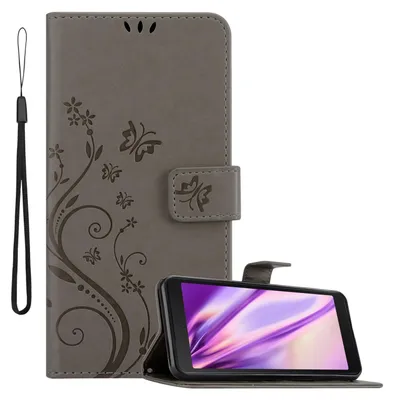 A grey flip phone case with a floral and butterfly design is shown open, with a smartphone inside. A black wrist strap is attached to the left side of the case.