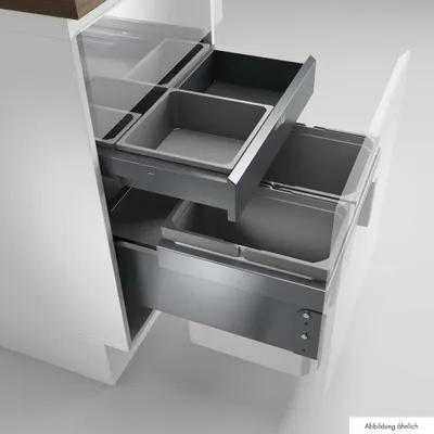 A kitchen cabinet with pull-out drawers containing waste bins.
