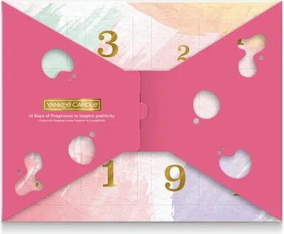 A pink advent calendar with cut-out shapes and gold numbers, designed to look like a bow tie.