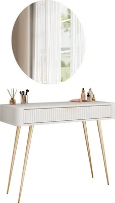 A white vanity table with gold legs and a round mirror above it, decorated with makeup and perfume bottles.