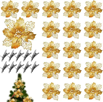 A collection of gold glitter poinsettia decorations and clips arranged on a white background, with a small section of a decorated Christmas tree in the bottom left corner.