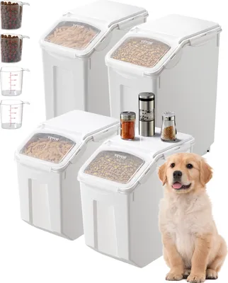 A set of white food storage containers with clear lids, some filled with dry food, and a golden retriever puppy sitting in front of them.