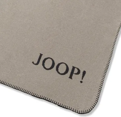 A close-up view of a blanket with the brand name printed on it.