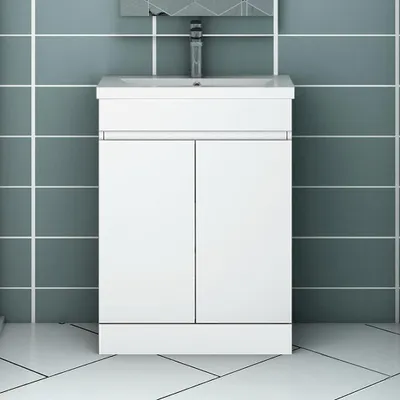 A white bathroom vanity with a sink and faucet, set against a tiled wall and floor.