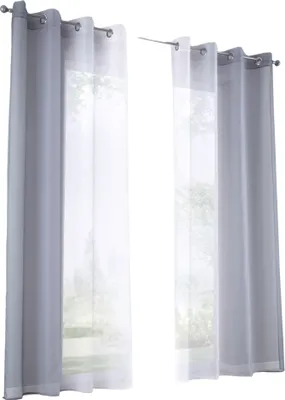 Two sets of curtains hanging on curtain rods, with a view of trees and greenery visible through the sheer inner curtains.