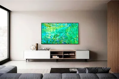 A modern living room with a large TV mounted on the wall above a media console.