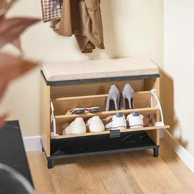 A shoe bench with storage in a hallway setting, with coats hanging above.