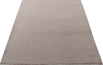 A plain, neutral-colored rug is shown from a slightly elevated angle against a white background.