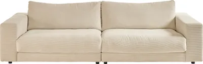 A studio shot of a cream-colored corduroy sofa.
