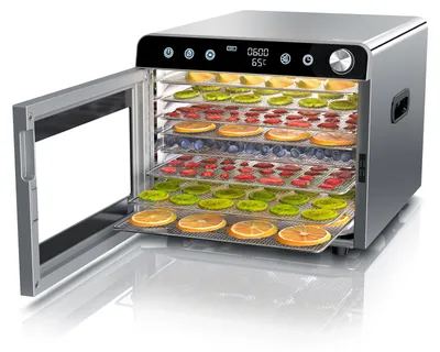 A food dehydrator with multiple trays filled with dried fruits and berries, with the door open.