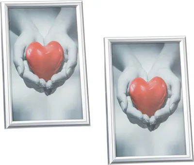 Two silver picture frames, each holding a black and white photo of hands holding a red heart.