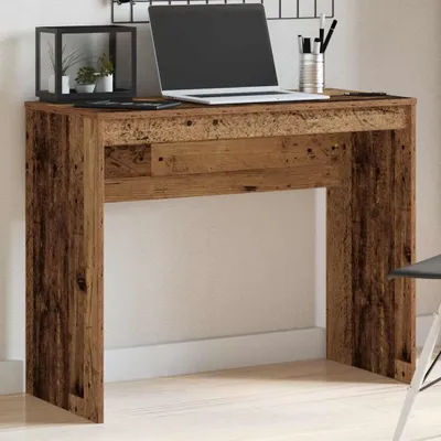 A rustic wooden desk with a laptop and decorative items on top.