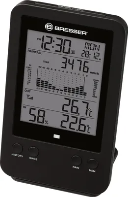 A black digital weather station displaying time, date, rainfall data, and indoor/outdoor temperatures and humidity.