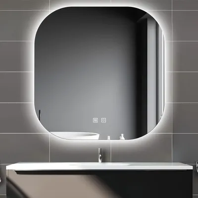 A modern bathroom vanity with a large, illuminated mirror above it.
