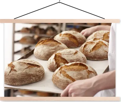 Produktbild von MuchoWow® Textilposter Ein Bäcker trägt ein Tablett mit Brot 120x80 cm mit holzfarbenen Rahmen - Aufhängeset