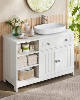 A white bathroom vanity with a sink and storage.