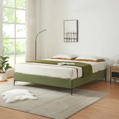 A bedroom scene with a green bed frame, white bedding, and a green throw blanket.