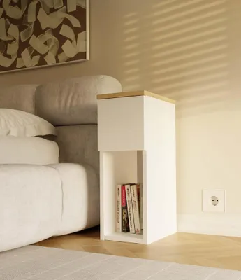 A bedside table next to a bed in a bedroom.