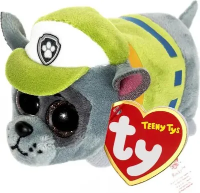 A close-up studio shot of a plush toy dog with a green hat and a red heart-shaped tag.