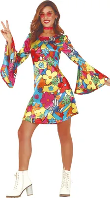 A woman wearing a colorful 70s-style dress and white boots, posing with a peace sign.