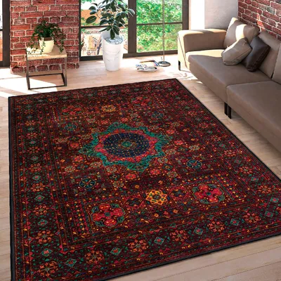 A Persian-style rug is laid out on a wooden floor in a living room setting, with a sofa and a brick wall visible.