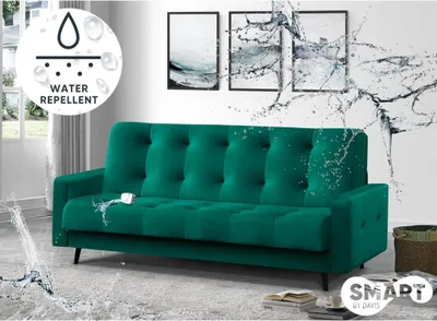 A green sofa is shown with water splashing on it, indicating its water-repellent feature. There are also framed pictures on the wall behind the sofa.