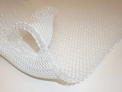 A close-up, angled view of a white 3D mesh matting material.