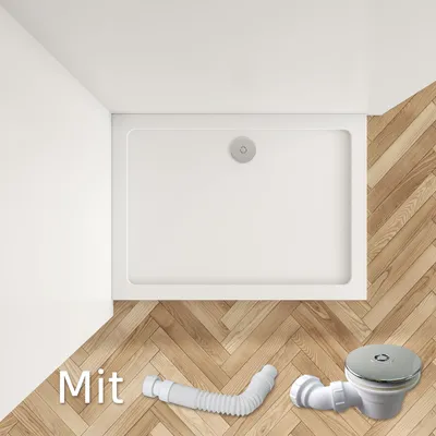 A white shower tray with a drain is shown on a wooden floor, along with a flexible drain pipe and a drain fitting.