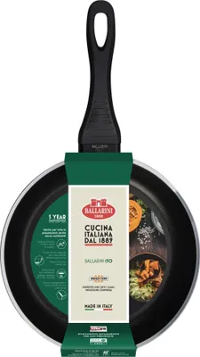 A black frying pan with a green and white product label attached to it, set against a white background.