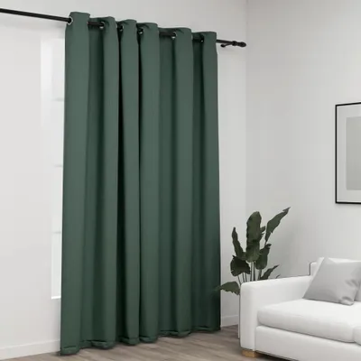 A green curtain hanging from a rod in a room with a white wall and a couch in the background.