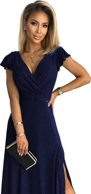 A woman wearing a navy blue dress and holding a clutch.