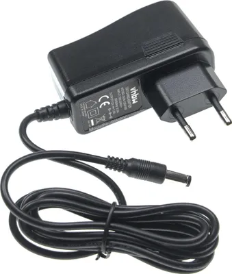 A black power adapter with a coiled cable and a European plug.