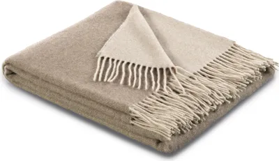 A folded blanket with fringe detail.