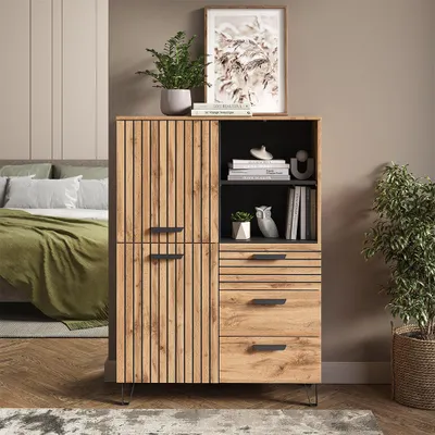 A wardrobe in a bedroom setting, next to a bed with green bedding.