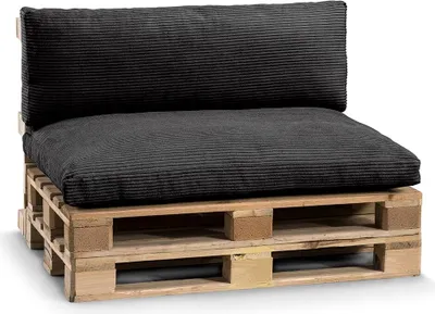 A black cushion set on a wooden pallet.
