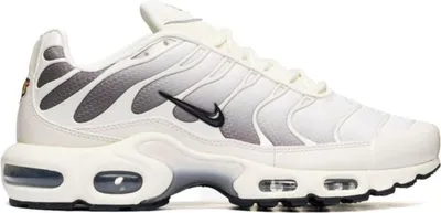A side view of a white Nike Air Max Plus sneaker with gray gradient detailing.