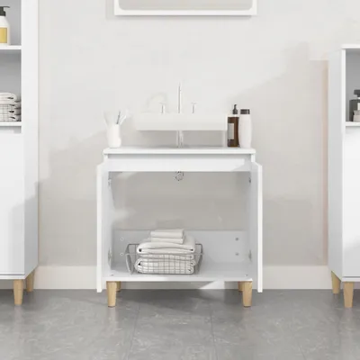 A white bathroom vanity with an open cabinet showcasing folded towels inside, next to a wall and sink.