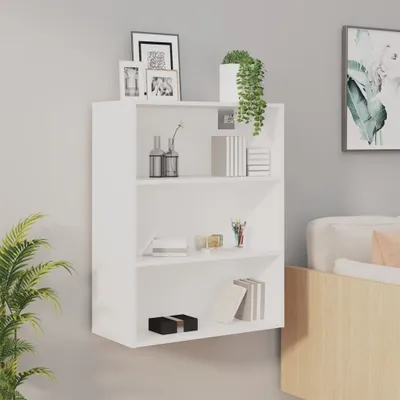 A white wall-mounted shelf unit with decorative items on it, next to a bed.