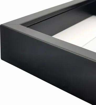 A close-up view of the corner of a black shadow box frame.