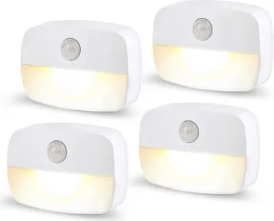 Four white LED night lights with motion sensors are arranged in a grid on a white background.