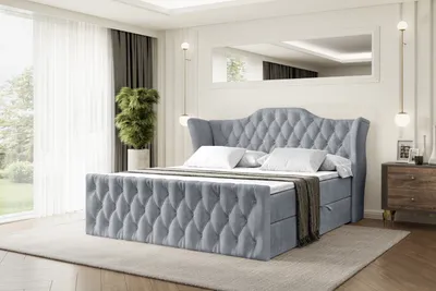 A bedroom scene with a large upholstered bed as the main focus.